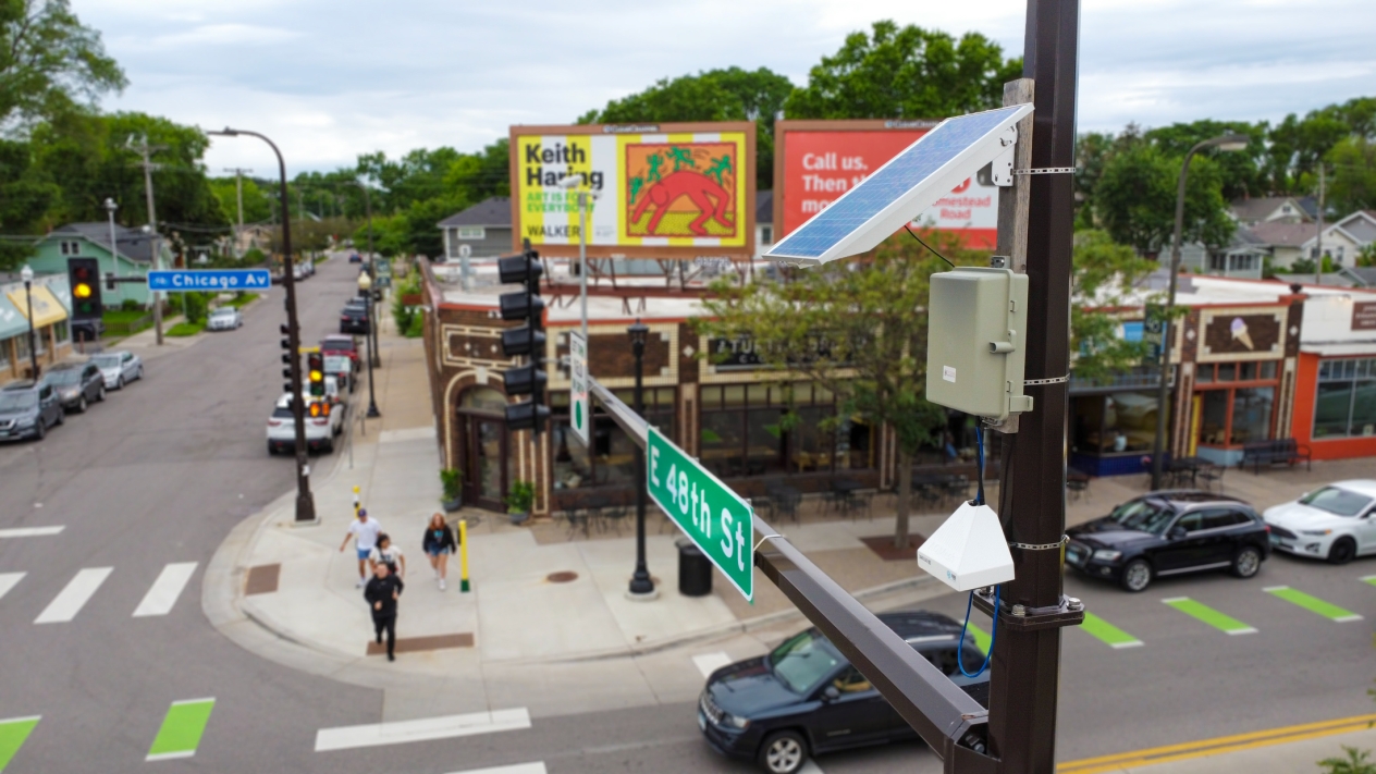 Air monitoring equipment and a small solar panel attached to the top of a utility pole at the corner of 48th Street and Chicago Ave in Minneapolis.