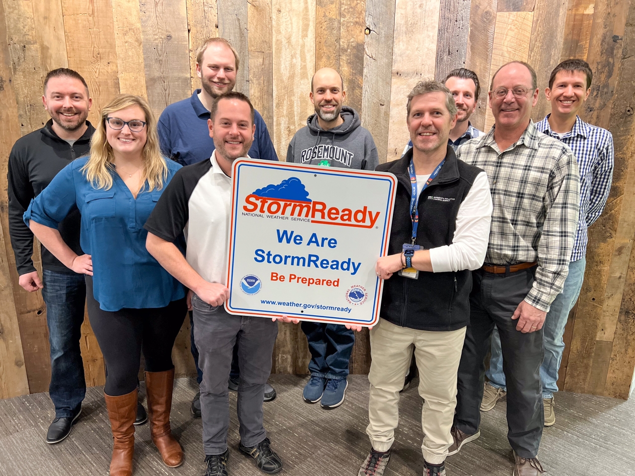 Group of people holding a sign that reads Storm Ready, we are storm ready, be prepared.