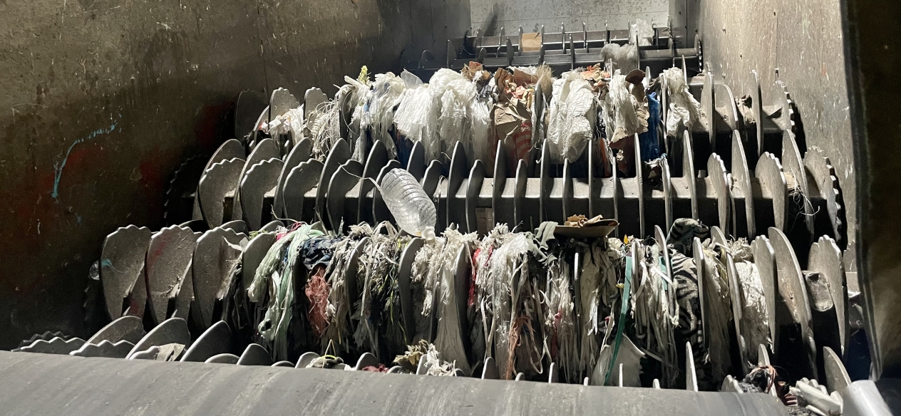 plastic bags and other tanglers clog up the gears of a specialized sorter at a material recovery facility