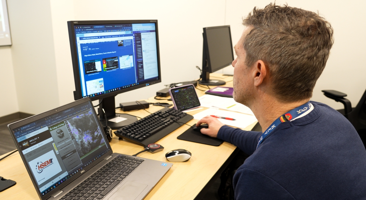 A man looking at computer screens.